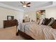 Comfortable bedroom with a ceiling fan, stylish decor, and a large dresser and television at 8592 Sentry Cir, North Charleston, SC 29420