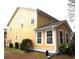 The yellow siding and white trim create a clean, modern look at 8592 Sentry Cir, North Charleston, SC 29420