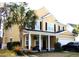 Inviting two-story home featuring a covered front porch and a well-manicured lawn at 8592 Sentry Cir, North Charleston, SC 29420