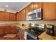 Well-equipped kitchen with stainless steel appliances, granite countertops, and warm wood cabinetry at 8592 Sentry Cir, North Charleston, SC 29420