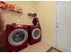 Functional laundry room with modern red appliances, storage shelves, and convenient access at 8592 Sentry Cir, North Charleston, SC 29420