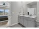 Bathroom with double sink vanity, gray cabinets and view into the bedroom at 87 Morning Song St, Summerville, SC 29485