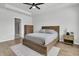 Bright bedroom features a ceiling fan, wood floors, tray ceiling, and en-suite bathroom access at 87 Morning Song St, Summerville, SC 29485