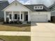 Charming one-story home featuring a covered porch, black shutters, and a two-car garage at 87 Morning Song St, Summerville, SC 29485