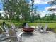 Enjoy the fire pit surrounded by Adirondack chairs, lush greenery, and green space at 87 Morning Song St, Summerville, SC 29485
