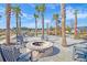 Relax and enjoy the neighborhood fire pit, surrounded by palm trees, tables and chairs, and green space at 87 Morning Song St, Summerville, SC 29485
