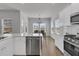 Bright eat-in kitchen with stainless steel appliances, white cabinets and backsplash, and hardwood floors at 87 Morning Song St, Summerville, SC 29485