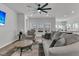 Bright living room with hardwood floors, modern ceiling fan, comfortable gray seating and view to kitchen at 87 Morning Song St, Summerville, SC 29485