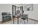 Modern office with black desk, dual monitors, stylish rug, french doors and contemporary artwork at 87 Morning Song St, Summerville, SC 29485