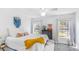 A bright bedroom featuring windows, a ceiling fan, a bed with a yellow blanket, and decorative furnishings at 947 E Estates Blvd # C, Charleston, SC 29414