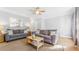 Bright living room with neutral walls, plush gray seating, and a stylish ceiling fan at 947 E Estates Blvd # C, Charleston, SC 29414