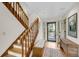 Inviting foyer with hardwood floors, wooden staircase, and a view of the front yard through the glass paneled front door at 1009 Seacrest Ln, Folly Beach, SC 29439