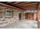 Back patio has a brick wall, concrete floor, exposed rafter beams, and a sliding glass door at 102 Brush Blvd, Goose Creek, SC 29445