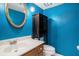 Bathroom with bright blue walls, modern vanity, and round mirror at 102 Brush Blvd, Goose Creek, SC 29445