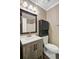 Well-lit bathroom features a modern vanity with gray wood grain and dark hardware, a dark cabinet, and an updated shower at 103 York Pl, Goose Creek, SC 29445