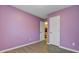 A bedroom with lavender painted walls, wood floor, a closet door, and a doorway at 103 York Pl, Goose Creek, SC 29445