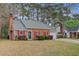 Charming brick home featuring a brick chimney, red shutters, and a tidy front yard at 103 York Pl, Goose Creek, SC 29445