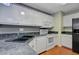 This kitchen offers white cabinetry, black countertops, and stainless steel appliances in a bright and functional space at 103 York Pl, Goose Creek, SC 29445