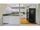 The kitchen features white cabinets, white appliances and a black refrigerator plus plenty of counter space at 103 York Pl, Goose Creek, SC 29445
