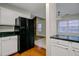 The kitchen features a black refrigerator, marbled countertops, white cabinets, and an opening to the dining room at 103 York Pl, Goose Creek, SC 29445
