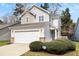 Charming two-story home features a garage and a welcoming front yard with lush greenery at 104 Chemistry Cir, Ladson, SC 29456