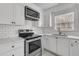 Bright kitchen with white cabinets, stainless steel appliances, and a subway tile backsplash at 105 Gourdin St, Saint Stephen, SC 29479