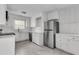 Spacious kitchen featuring stainless steel refrigerator, white cabinets and backsplash at 105 Gourdin St, Saint Stephen, SC 29479