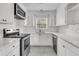 Bright, fully-equipped white kitchen with stainless steel appliances and subway tile backsplash at 105 Gourdin St, Saint Stephen, SC 29479