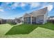 This home has a spacious backyard with lush lawn, screened-in porch, and outdoor grilling area at 107 Cotton Blossom Way, Summerville, SC 29485