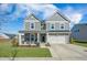 Charming two-story home with gray siding, a covered front porch, and a well-maintained lawn at 107 Cotton Blossom Way, Summerville, SC 29485