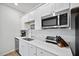 Well-lit kitchen features white cabinets, stainless steel appliances, and modern countertop with sink and a microwave at 107 Cotton Blossom Way, Summerville, SC 29485