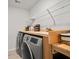 Clean laundry room includes front load washer and dryer, wood countertop and shelves at 107 Cotton Blossom Way, Summerville, SC 29485