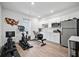 Spacious workout room with exercise equipment, white cabinets, and stainless steel refrigerator at 107 Cotton Blossom Way, Summerville, SC 29485
