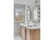 Bright bathroom featuring double vanity, quartz countertop, wood cabinets, stylish mirrors, and exterior view at 124 Beresford Creek St, Charleston, SC 29492