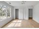 Bright bedroom with large windows, hardwood floors, white trim, closet, and modern lighting at 124 Beresford Creek St, Charleston, SC 29492