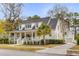 Beautiful two-story white home with a spacious front porch, manicured lawn, and a private driveway at 124 Beresford Creek St, Charleston, SC 29492