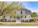 Charming two-story home featuring a welcoming white porch, lush landscaping, and classic architectural details at 124 Beresford Creek St, Charleston, SC 29492