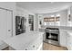 Open kitchen showcasing island, stainless appliances, breakfast nook and natural woven window coverings at 124 Beresford Creek St, Charleston, SC 29492