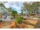 Expansive backyard features lush greenery, a cozy pergola, and a charming stone patio with a fire pit at 1327 Bob White Dr, Charleston, SC 29412