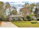 Charming single-story home featuring lush lawn, mature trees, and an American flag at 1327 Bob White Dr, Charleston, SC 29412
