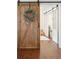 Open hallway view showcasing the hardwood floors, a rustic barn door and glimpse of a well-lit interior space at 1327 Bob White Dr, Charleston, SC 29412