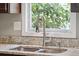 Close up on a kitchen sink, faucet, and granite countertops under a bright window at 1327 Bob White Dr, Charleston, SC 29412