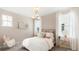 Cozy bedroom features soft pink accents, large windows, and stylish decor for a comfortable retreat at 1441 Clay Field Trl, Summerville, SC 29485