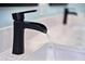 Close-up of the modern black waterfall faucet on the white marble vanity at 150 Etiwan Park St, Charleston, SC 29492