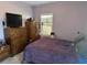 Bedroom features a bed, a wooden dresser, a window with wood blinds, and lavender-painted walls at 1561 Little Rock Blvd, Charleston, SC 29412