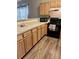 Bright kitchen with wood cabinets, black appliances, and wood-look floors at 1561 Little Rock Blvd, Charleston, SC 29412