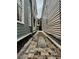 Narrow alleyway between houses with brick and gravel path leading to the home's entrance at 157 Tradd St, Charleston, SC 29401