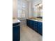 Bathroom with beautiful blue vanities, granite countertops, and a window with white shutters at 157 Tradd St, Charleston, SC 29401