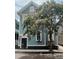 Charming blue home with black shutters, flowering tree and manicured garden at 157 Tradd St, Charleston, SC 29401