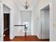 Hallway with wood floors leading to the top of a staircase, chandelier and white walls at 157 Tradd St, Charleston, SC 29401